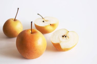 Çin altın armutları Nashi çeşitliliğini beyaz arka planda iki rauntluk bir bölüme ayırıp dilimledi. Gıda konsepti. Doğal yiyecek, meyve suyu ve jöle için meyve..