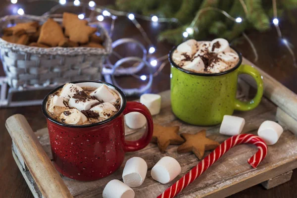 Winter hot drink cocoa, hot chocolate and marshmallows, homemade cookies on a wooden tray. Christmas holiday background.