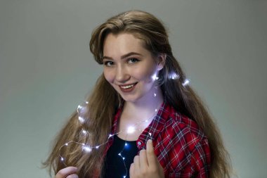 Kırmızı ekose gömlekli neşeli bir genç kız portresi, parlak çelenkli..