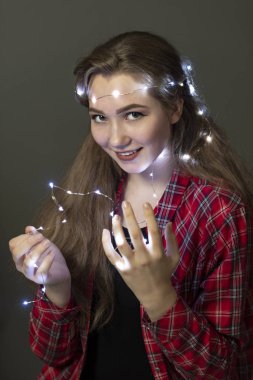 Kırmızı ekose gömlekli neşeli bir genç kız portresi, parlak çelenkli..