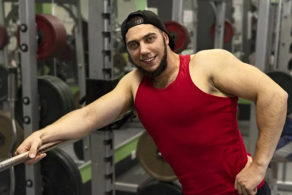 Portrait of a strong, muscular young men in the gym. Happy positive athlete smiling.