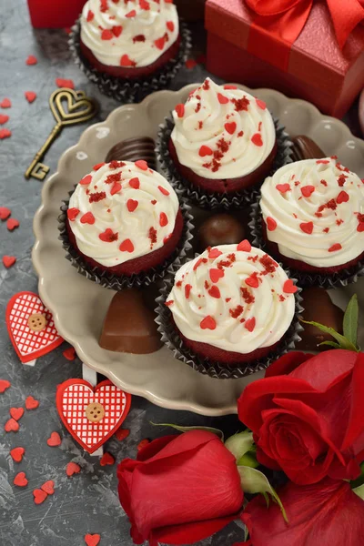 Cupcakes, chocolate e rosa em um fundo cinza — Fotografia de Stock