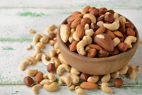 Mix of different nuts in a wooden bowl — Stock Photo, Image