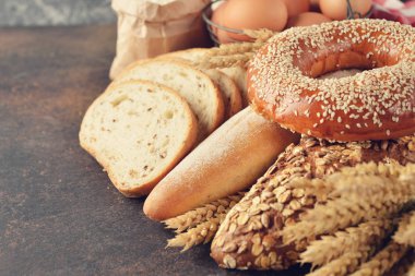 Çeşitli ekmek ve buğday kahverengi zemin üzerine