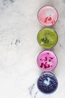 Beyaz arkaplanda farklı renkli latte türleri