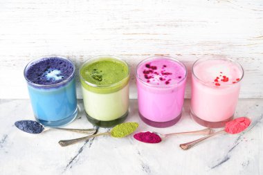 Beyaz arkaplanda çeşitli renkli latte türleri