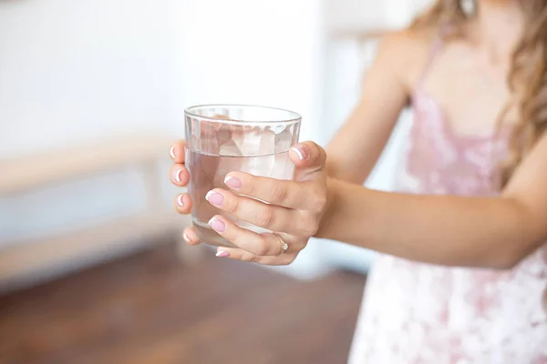 Manos femeninas sosteniendo un vaso de agua transparente. Estilo de vida saludable —  Fotos de Stock