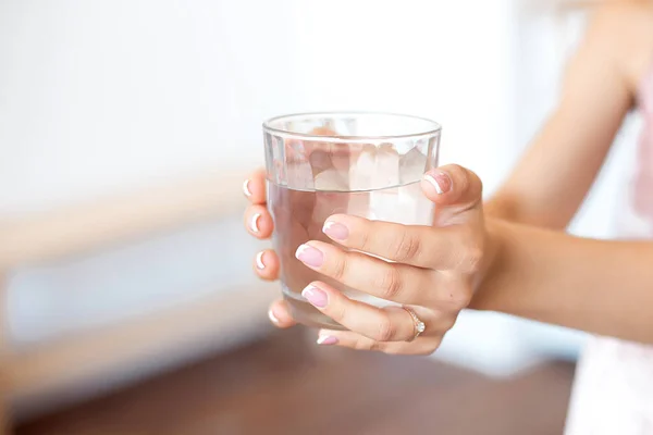 Manos femeninas sosteniendo un vaso de agua transparente. Estilo de vida saludable —  Fotos de Stock