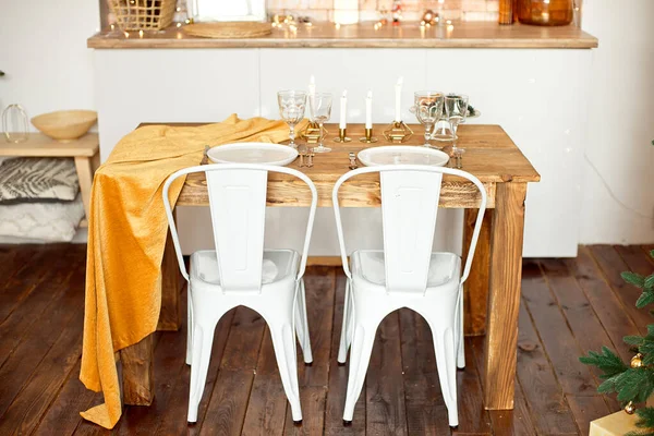 Gyönyörű ünnepélyesen berendezett skandináv stílusú szoba, egy ünnepi asztal asztallal és egy karácsonyfa ajándékokkal alatta — Stock Fotó