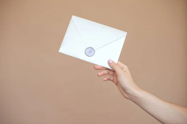 Photo en gros plan de mains féminines avec sceau de cire avec enveloppe d'invitation, chèque-cadeau, carte postale, carte d'invitation de mariage — Photo