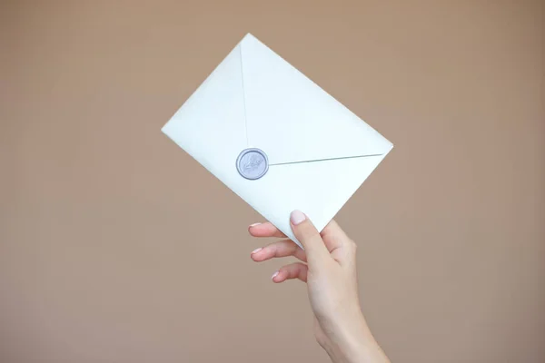 Close-up foto de mãos femininas com selo de cera com envelope de convite, certificado de presente, cartão postal, cartão de convite de casamento — Fotografia de Stock