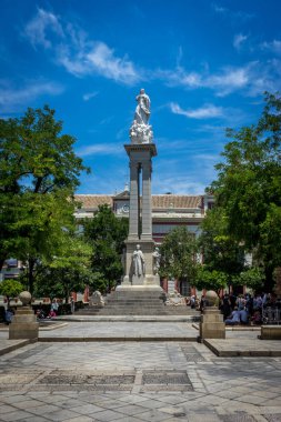 Parlak bir güneş üzerinde arka planda insanlarla Hıristiyan anıt