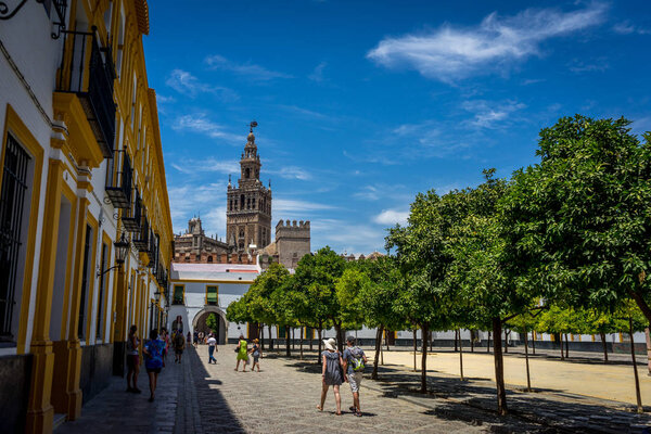 The Giralda Bell tower with people in the foreground in Seville,