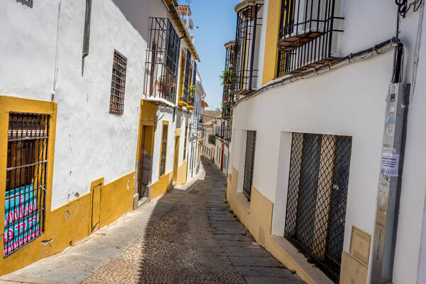 Empty streets of Cordoba on a bright summer day with blue sky and buildings on either side