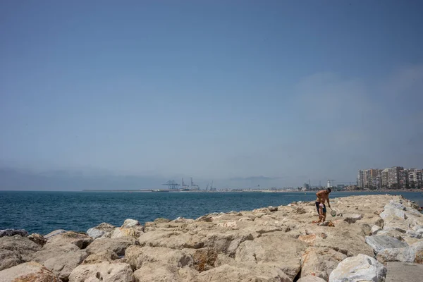Ojciec pomoc syna chodzić na skałach na plaży Malagueta — Zdjęcie stockowe