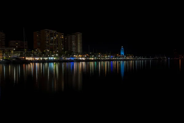 Blick auf Malaga Stadt und Leuchtturm und ihre Reflexionen auf dem Wasser — Stockfoto