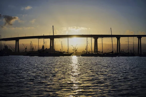Sunrise behind silhouettes of boats and the Coronado Bridge, San Diego, California — Stock Photo, Image