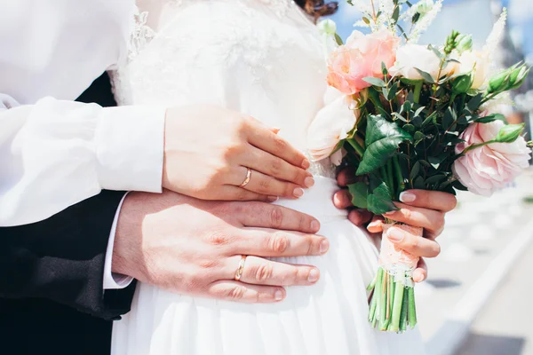 Mani e anelli su bouquet da sposa — Foto Stock