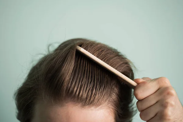 Homem com cabelo saudável segurando pente — Fotografia de Stock