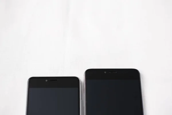 Современные смартфоны на белом фоне — стоковое фото