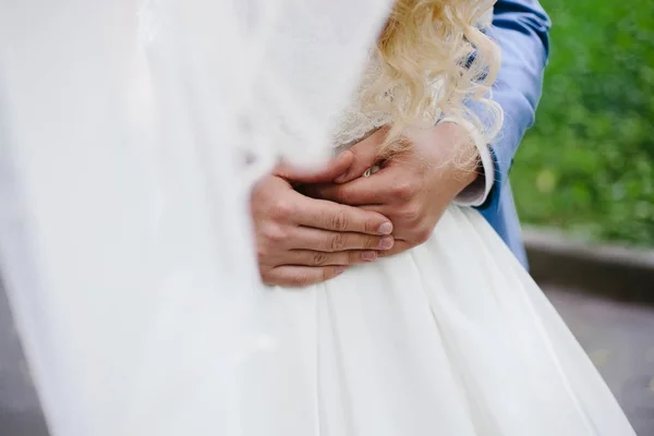 Brudgummen på bröllop gå kramar försiktigt brudens midja. — Stockfoto