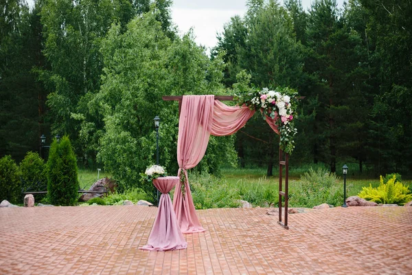 Arch for the wedding ceremony. Arch, decorated with beautiful fresh flowers and cloth. Bordeaux color. Registration at the place of marriage. — Stock Photo, Image