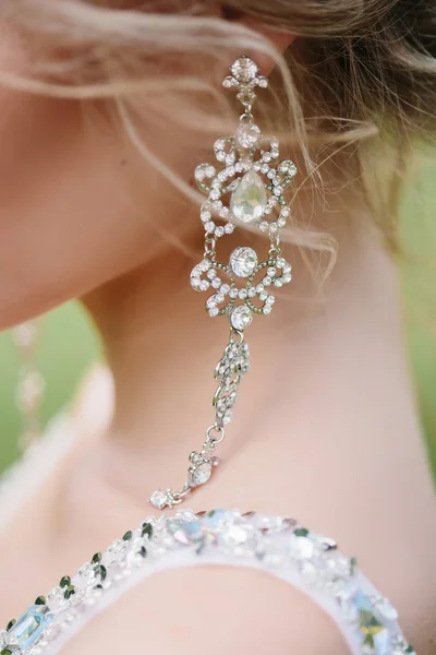 Hochzeitsvorbereitungen. schöne, glückliche Brautkleider Ohrringe vor der Hochzeit. — Stockfoto