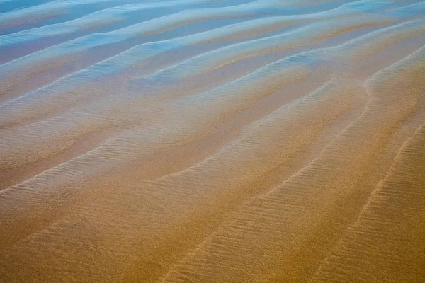 Närbild Detaljer för en strand med reflekterande blå himmel — Stockfoto