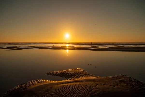 Jedna neidentifikovatelná osoba na pláži při západu slunce — Stock fotografie