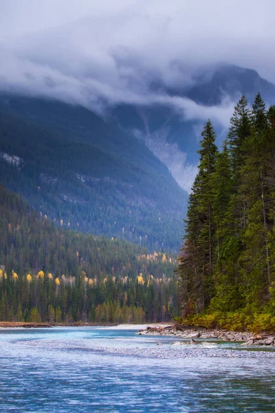 Un fiume che scorre tra le montagne in una giornata nuvolosa e tempestosa — Foto Stock