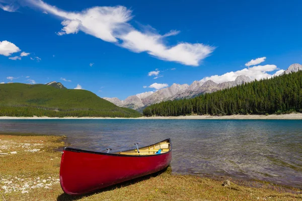 Canoa vermelha na margem de um lago de montanha — Fotografia de Stock