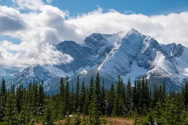 Une montagne enneigée entourée de nuages — Photo