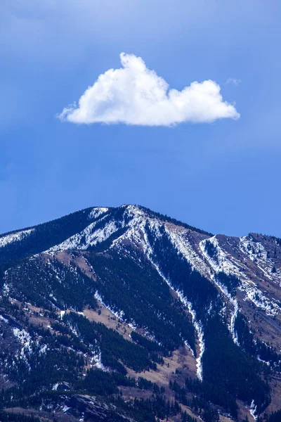 Un seul nuage au-dessus d'un sommet de montagne — Photo