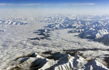 Himalaya Dağları bulutlar altında. Uçak - Tibet görüntülemek