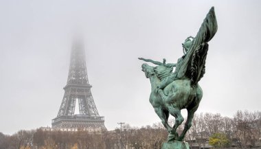 Eiffel Kulesi ve Bir-hakim heykeli sisli bir günde