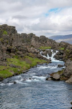 İzlanda 'daki Thingvellir Ulusal Parkı' ndaki lav kayaları arasında Oexara Nehri 'nin akışı..