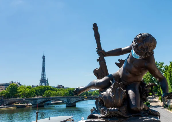 Face mask on Child with Crab statue on Alexandre III during Coronavirus epidemic with eiffel tower in the background- Paris, France