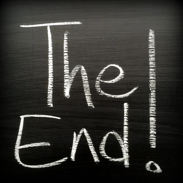 The phrase The End! written in white chalk on a blackboard — ストック写真