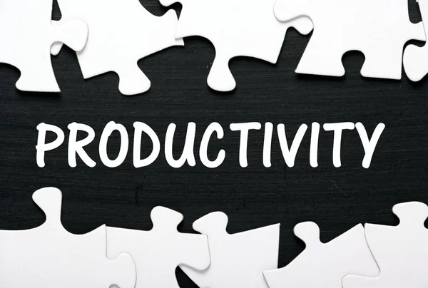 The word Productivity in white text on a blackboard between jigsaw puzzle pieces — Stock Photo, Image