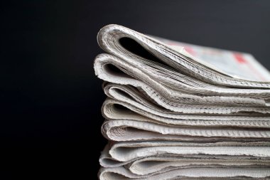 Siyah arka planda bir yığın gazete