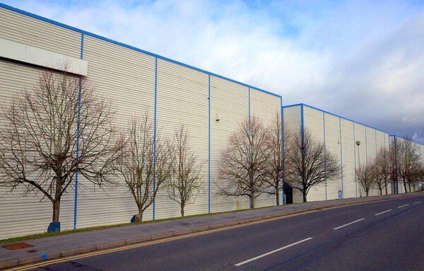 Bracknell,England - January 29, 2018: Wide angle view of warehouses in a row beside an empty tree-lined road on an industrial estate in Bracknell,England