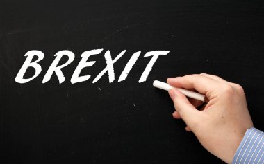 Erkek el İngiltere ve Avrupa Birliği bırakmak oy İngiltere başvuru olarak bir kara tahta üzerinde Brexit kelime yazma