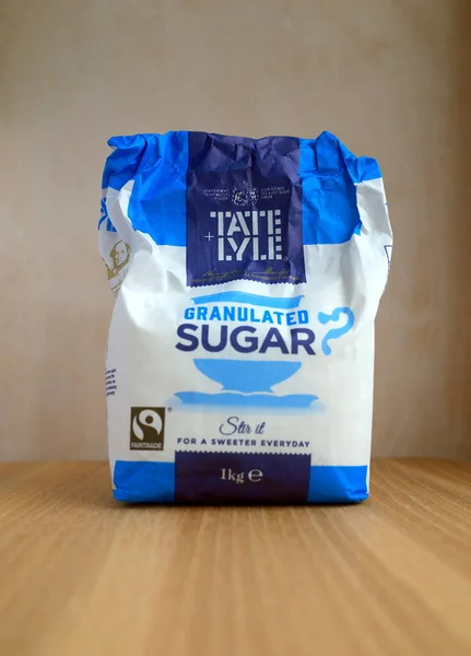 布拉克内尔 2018年4月13日 部分消耗了一公斤大袋的泰特和莱尔在木制的背景下的砂糖 1921年 泰特和亚伯兰在伦敦合并了各自的糖业公司 — 图库照片