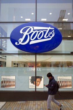 Bracknell, İngiltere - 16 Nisan 2018: Vitrini Boots perakende deposu ve eczane, Bracknell, İngiltere tarafından bir yaya yolcu.