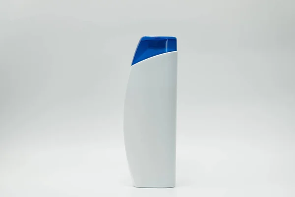 Garrafa cosmética com tampa azul isolada em fundo branco com etiqueta em branco e espaço de cópia, basta adicionar seu próprio texto . — Fotografia de Stock