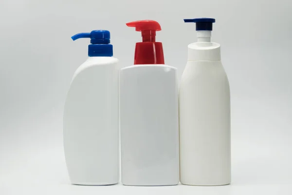 Tres botellas blancas con bomba roja y azul con espacio para copiar y etiqueta en blanco —  Fotos de Stock