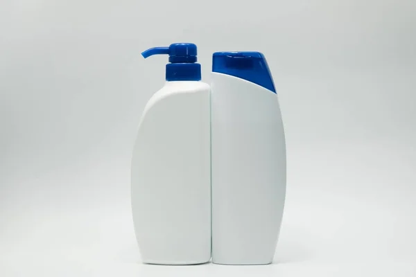 Botellas de champú y acondicionador con tapa azul sobre fondo blanco con espacio para copiar. Uso para anunciar el concepto de champú y acondicionador — Foto de Stock