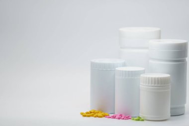 Boş etiket ve kopya alanı, beyaz zemin üzerine kapalı beyaz şişe ile renkli tablet hap sadece kendi metninizi ekleyin. Reklam Takviyeler ve vitaminler kavramı kullanıma
