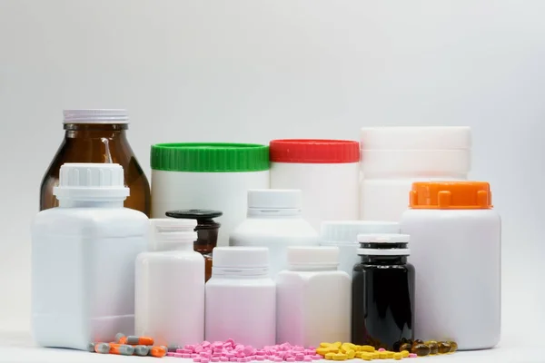 Pastillas y botellas con tapa sobre fondo blanco con espacio para copiar y etiqueta en blanco, solo agregue su propio texto. Salud y concepto de industria farmacéutica . — Foto de Stock