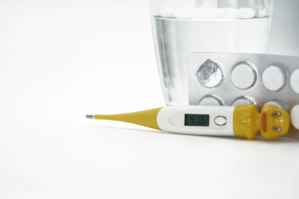 Bir bardak su ve hap, beyaz arka plan üzerinde termometre — Stok fotoğraf